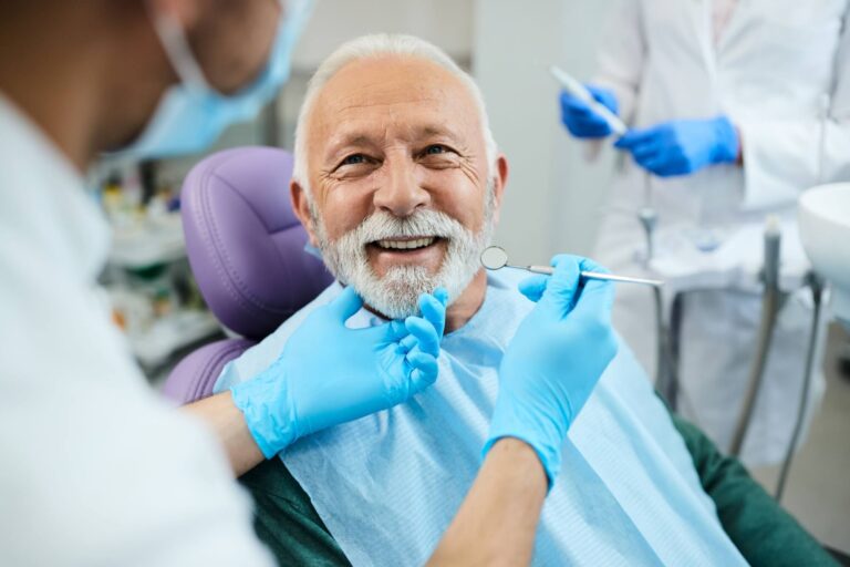 Happy mature man during teeth check-up at dental clinic