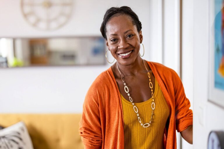 smiling mature woman standing in her apartment