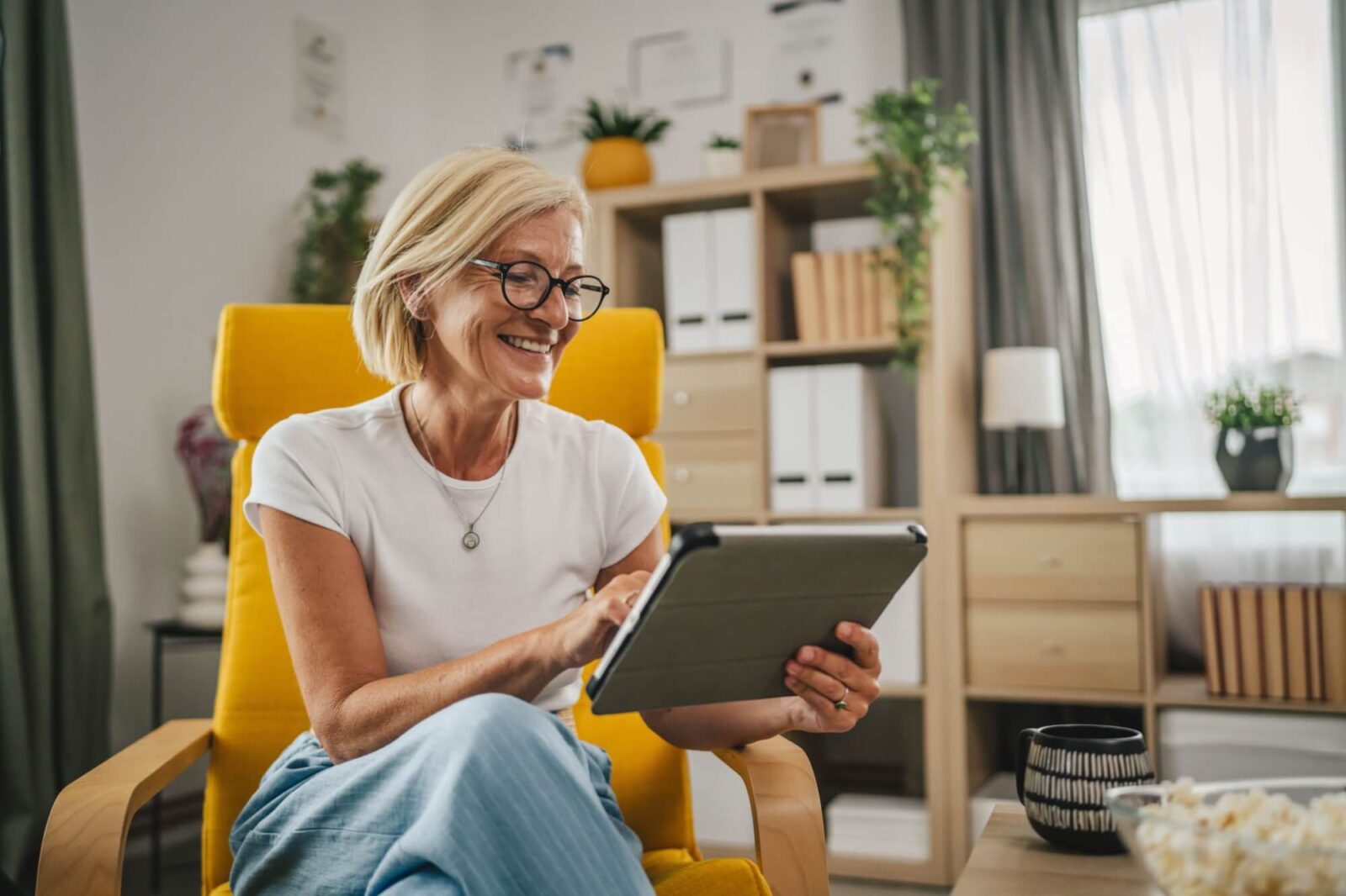 Mature senior woman sit at home and use Tablet computer