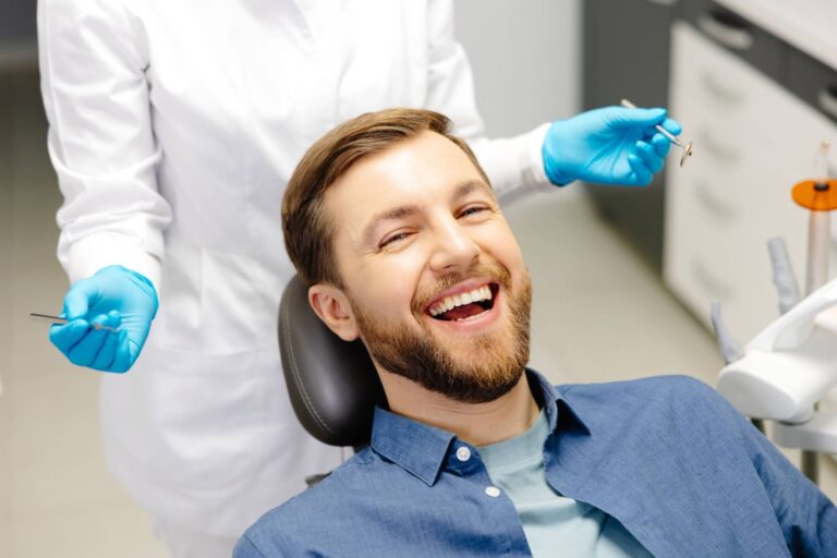 happy man sitting at dentist chair in modern clinic