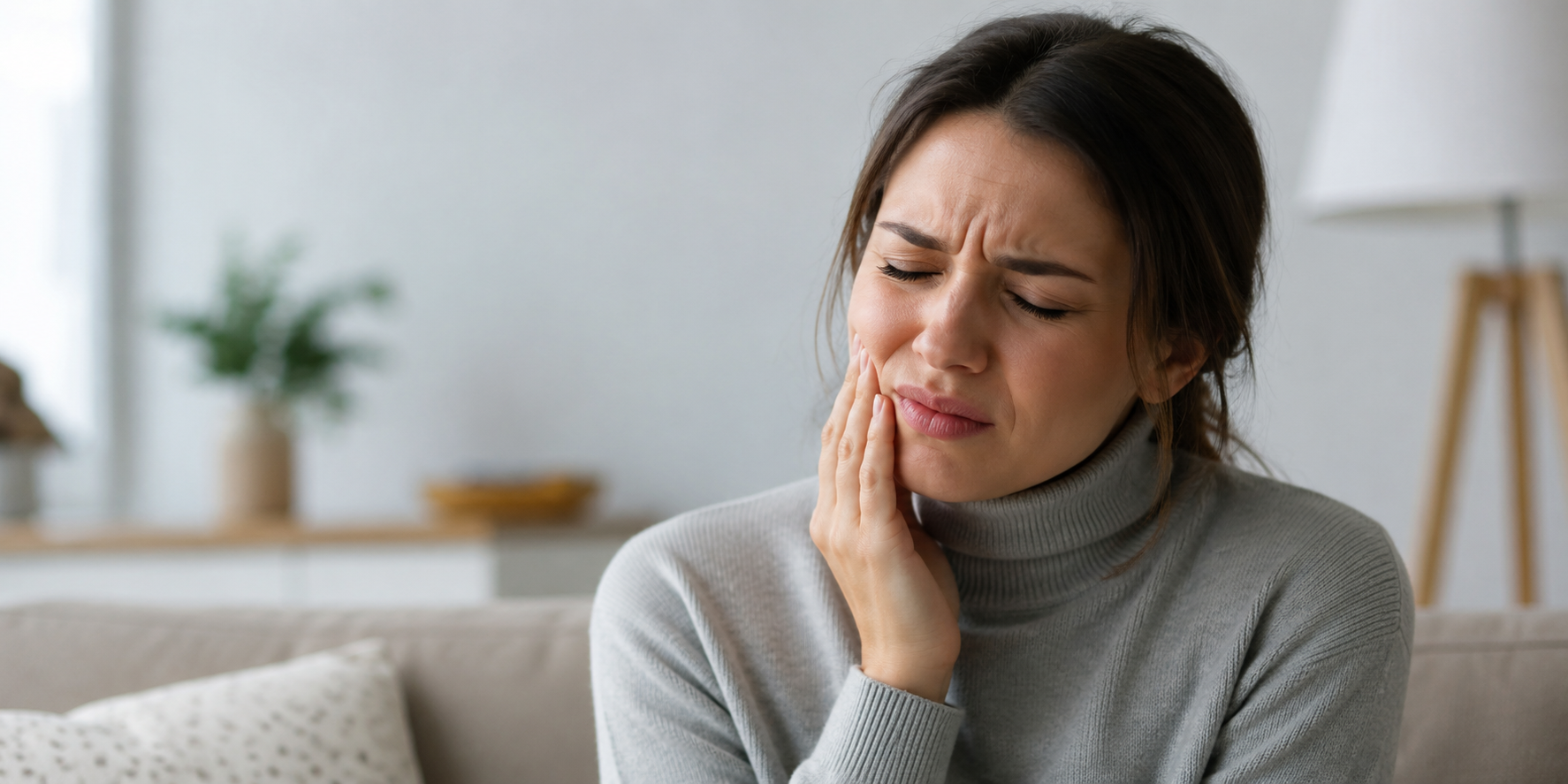 Woman holding her jaw in pain after noticing signs she needs a root canal